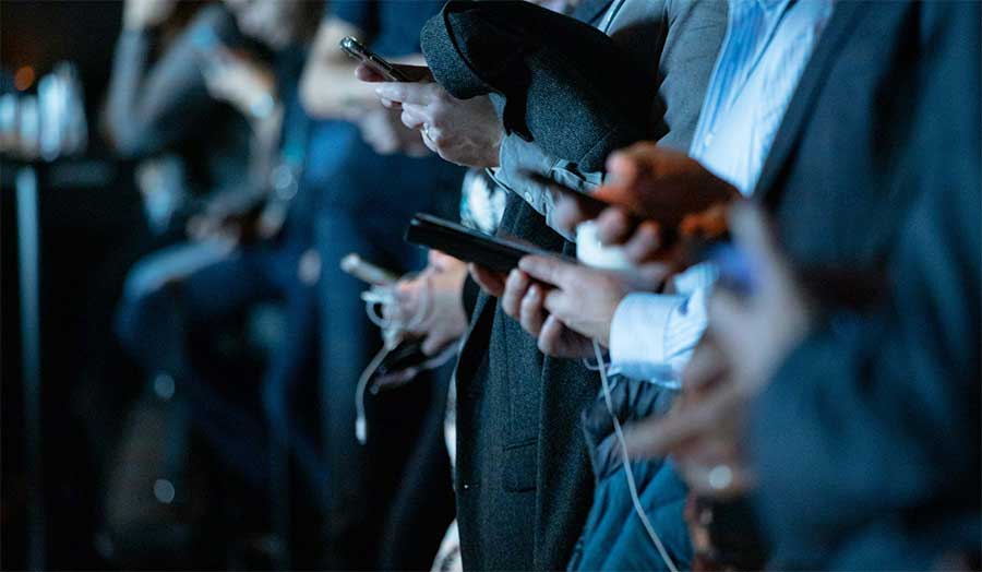 A row of people looking at their phones