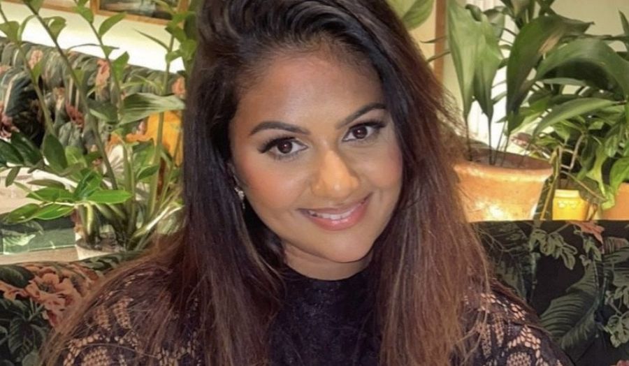 A young woman with long hair smiles 