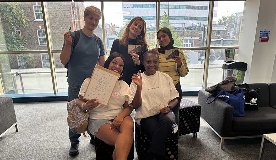 5 students celebrate winning the scavenger hunt in the library