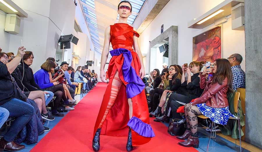 male model on catwalk in red garment