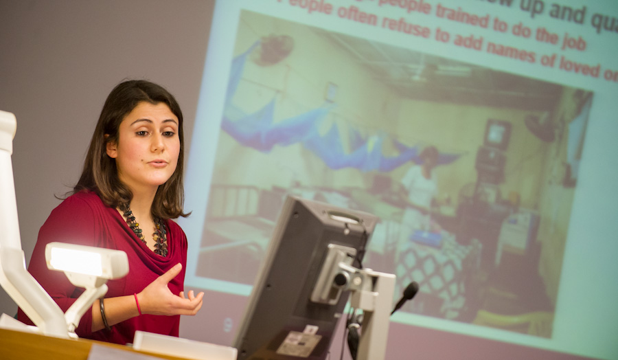 Cristina Leggio standing in front of a powerpoint presentation mid-talk to students