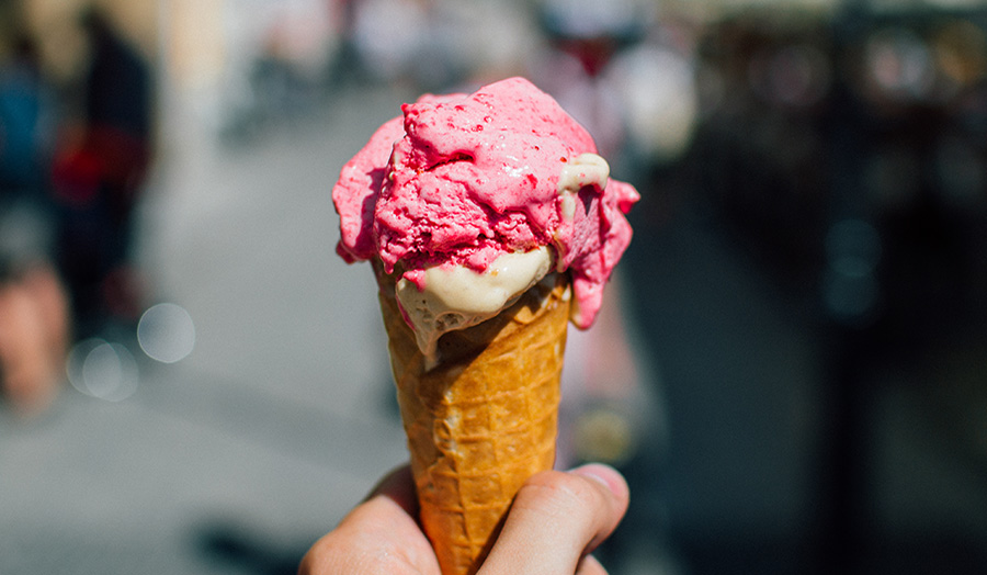 Hand holding ice cream in a cone