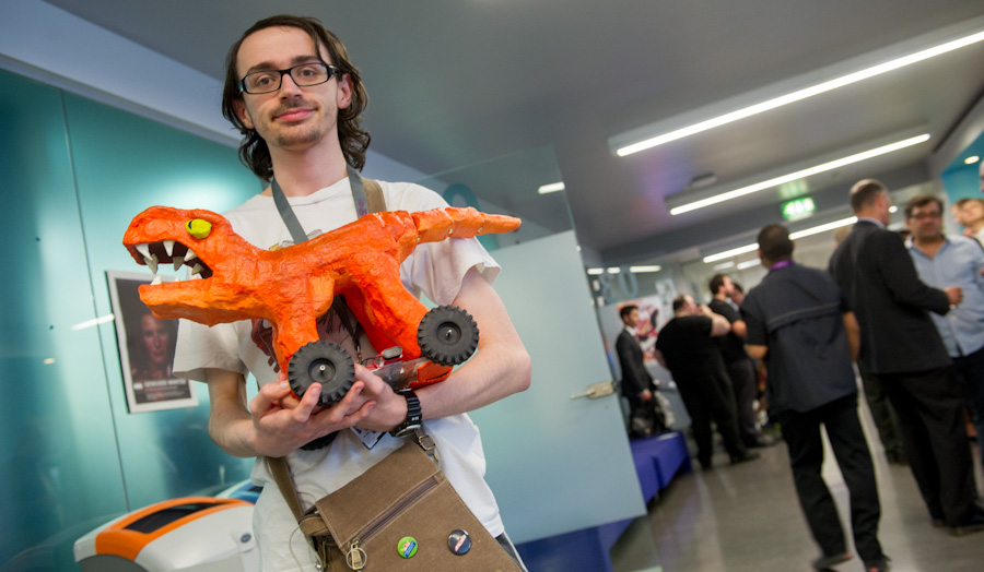 Matthew holds his robotic t-rex toy in the blue lounge at London Met