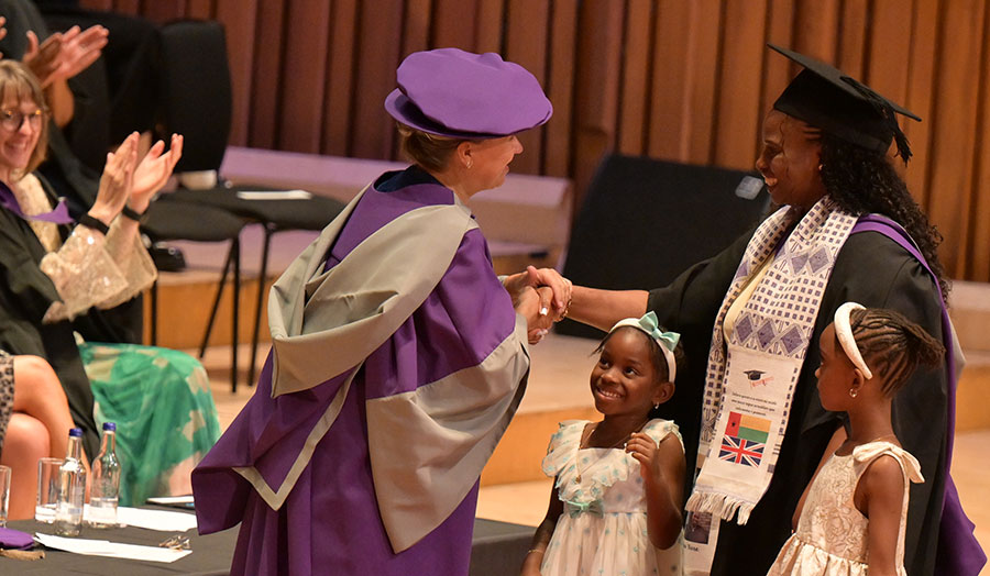 London Met mature student with her two children being congratulated at graduation