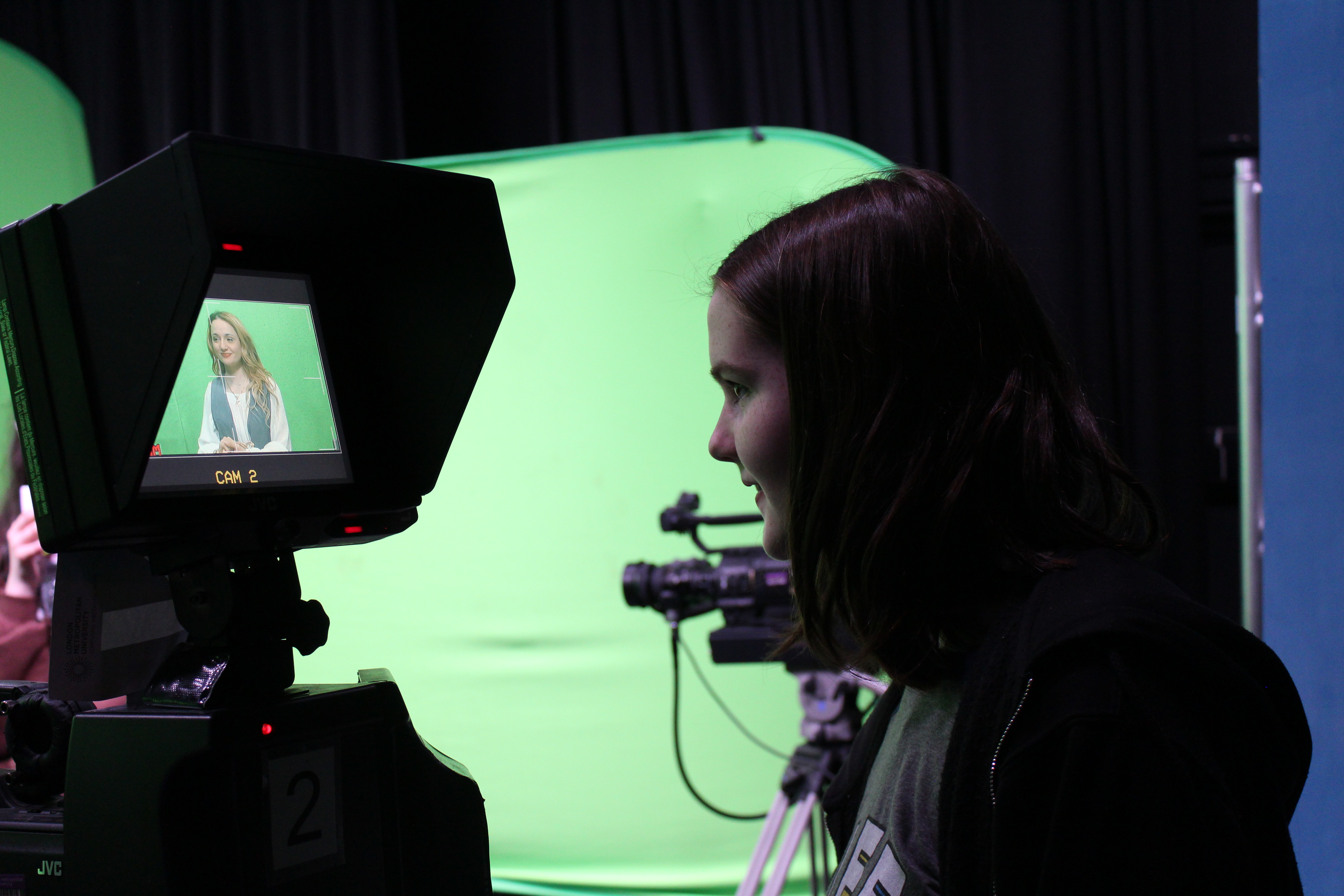 Student in front of a camera and green screen