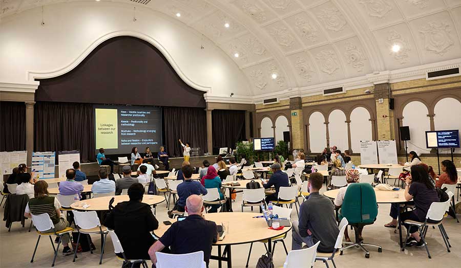 An audience listening to speakers in the Great Hall at London Metropolitan University