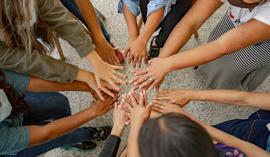 Several people's hands placed together in a circle