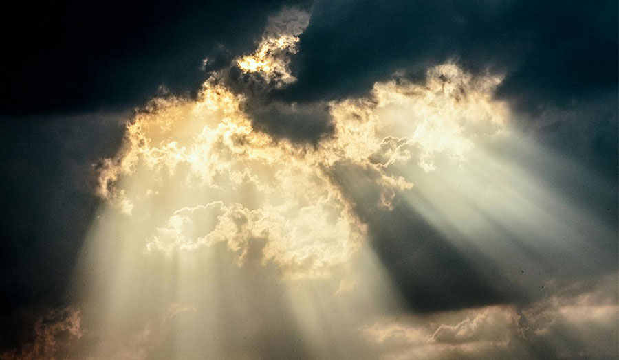 Sun streaming through dark clouds