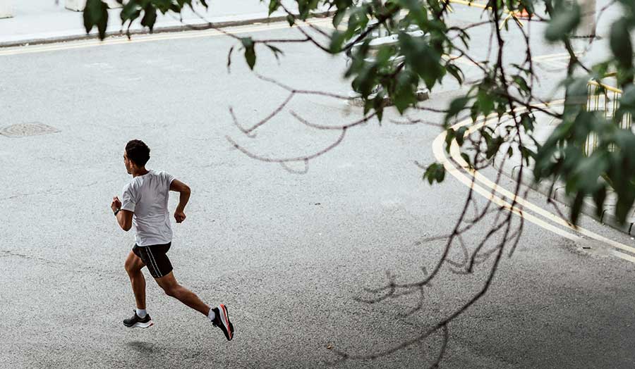 A boy running near trees