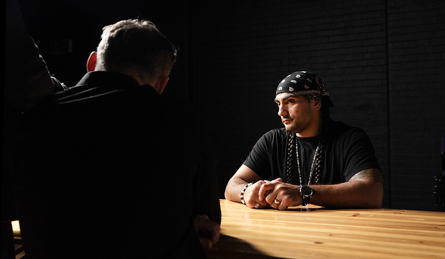 A person sits spotlit at a table