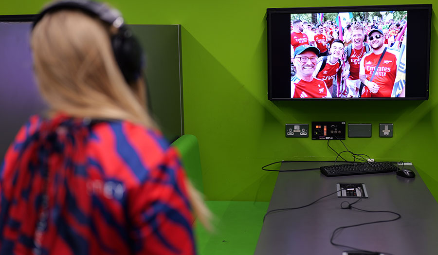 A woman wearing headphones looks at a screen