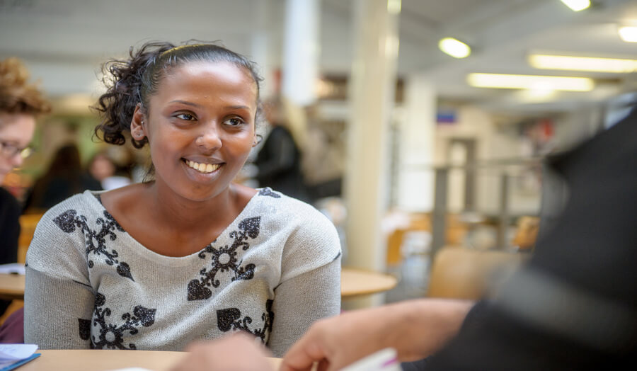 An image of a female student talking to a fellow student.