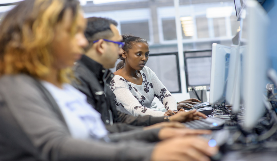 Image of three postgraduate students working together at computers 