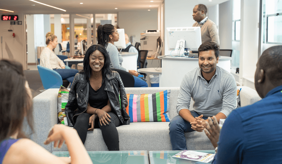 A group of students sitting on sofas talking to each other