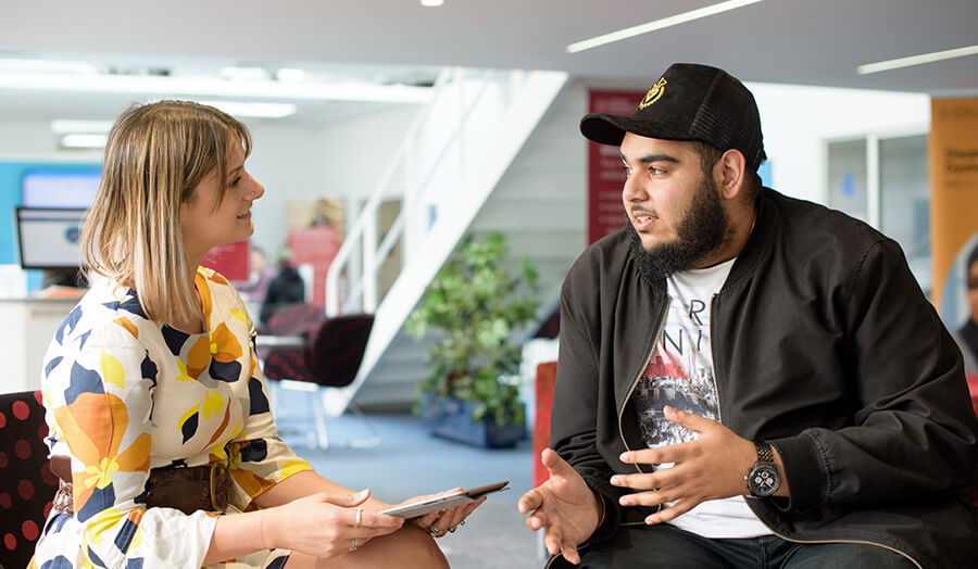 a member of staff and students talking to each other