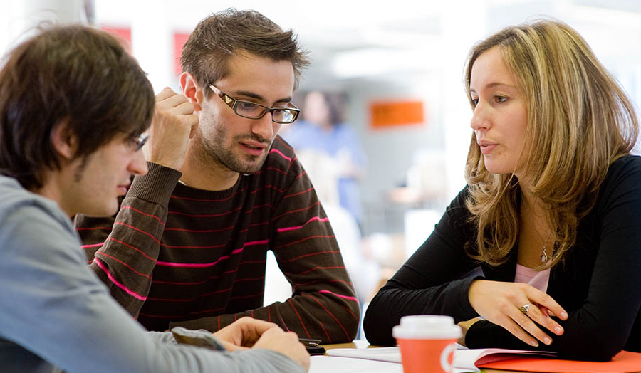 Male and female students talking in a group