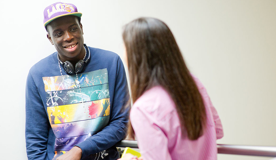 Male student talking to female student (latter has her back to the camera)