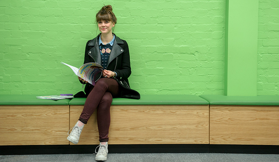 A female student sitting reading a book