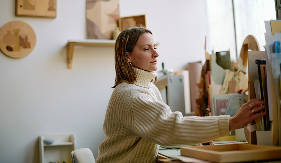 A mid-shot of Chelsea sitting in her work studio