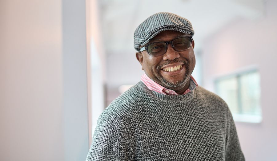 Ifeanyi Nwachukwu smiling, with University buildings behind him