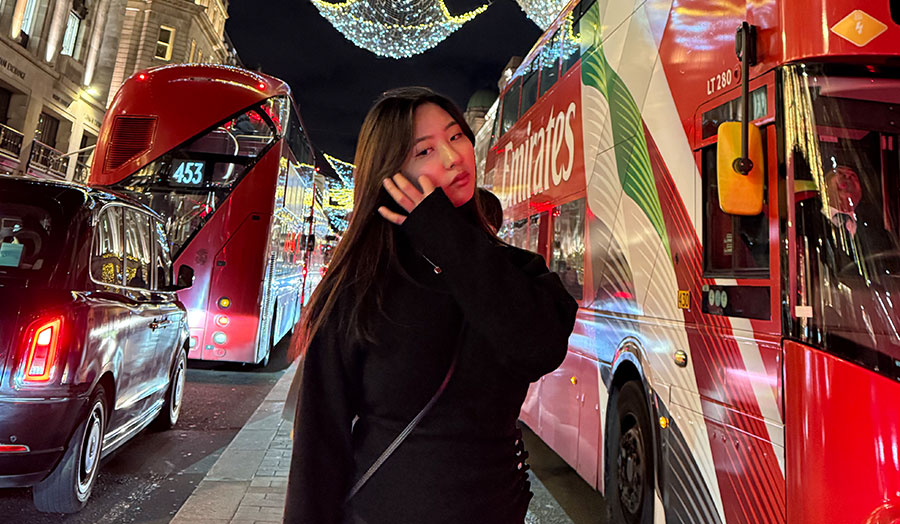 Mirin pictured with Christmas lights and red buses in central London