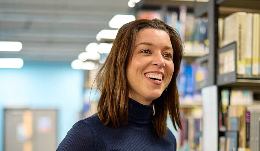 Psychology student Nayara smiling in our library