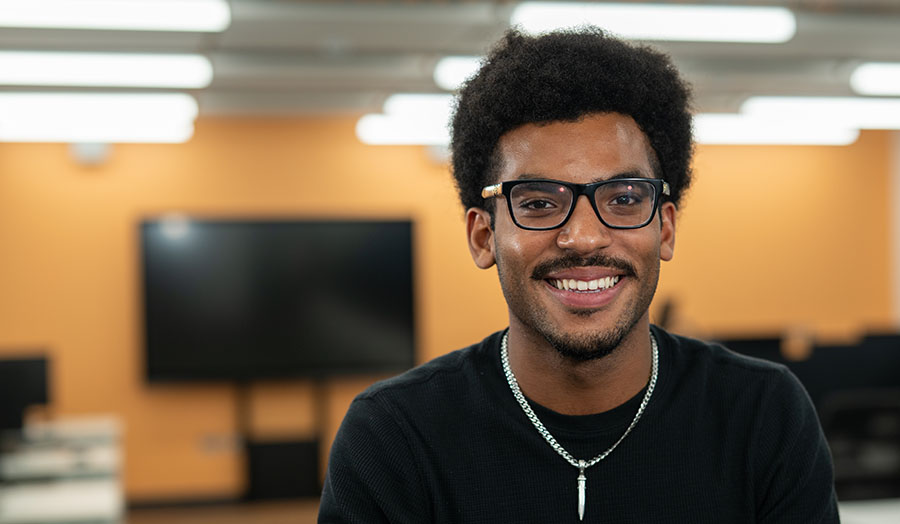 Student Roydell in a classroom, smiling