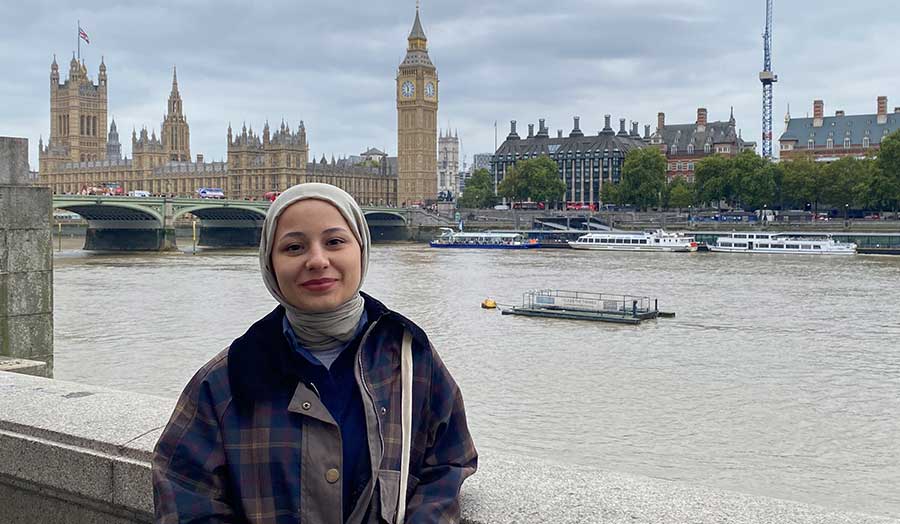 Serra standing in front of the Thames and Houses of Parliament