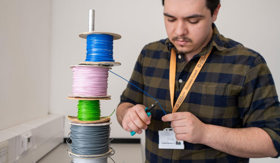 An electronic student cutting wire from a roll